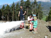 Im Rahmen des Feuerwehr-Aktionstages besuchte uns am 27. Juni 2014 die Volksschule und der Kindergarten Karrösten. Bei dieser Veranstaltung konnten die Kinder die Feuerwehr, ihre Aufgaben und Ausrüstung kennen lernen. Gemeinsam mit dem Feuerwehr-Maskottchen Flori wurden zuerst die Volksschüler und anschließend die Kindergartenkinder mit dem TLF und LFB abgeholt. Nach einer Fahrt durch unser Dorf folgte eine Löschervorführung am Gelände der Bodenaushubdeponie. Dabei wurde den Kindern die Gefährlichkeit von Feuer demonstriert. Unter Aufsicht durften die Kinder einen Brand mit Feuerlöscher und Löschdecke bekämpfen. Nach der Rückfahrt ins Feuerwehrhaus folgte eine wohlverdiente Pause für Groß und Klein. Anschließend wurde den Kindern die Feuerwehr in mehreren Stationen vorgestellt. Station 1: Zivilschutz – Bei dieser Station erhielten die Kinder einen Einblick in den Zivilschutz und die typischen Gefahren. Station 2: Alarmierung – Hier konnten die Kinder verschiedenste Alarmierungsmittel kennenlernen. Weiters wurde ihnen an einer Karte in der Florianstation unser Einsatzgebiet gezeigt. Station 3: Bekleidung – Unter fachkundiger Anleitung wurde den Kindern die Schutzbekleidung der Einsatzkräfte vorgestellt. Dabei durfte das Anprobieren von Einsatzjacke, Stiefel und Helm natürlich nicht fehlen. Station 4: Fahrzeuge – Bei der vorletzten Station konnten die Kinder unsere Einsatzfahrzeuge von innen und außen genauestens unter die Lupe nehmen. Weiters wurden ihnen die verschiedensten Feuerwehr-Ausrüstungsgegenstände und deren Funktion gezeigt. Station 5: Spritzen – Sichtlich am meisten Spaß hatten die Kinder beim Zielspritzen mit der Kübelspritze und Gartenschlauch auf die Spritzwand. Mit einem gemeinsamen Gruppenfoto endete ein spannender und lehrreicher Tag für die Kinder der Volksschule und des Kindergartens.